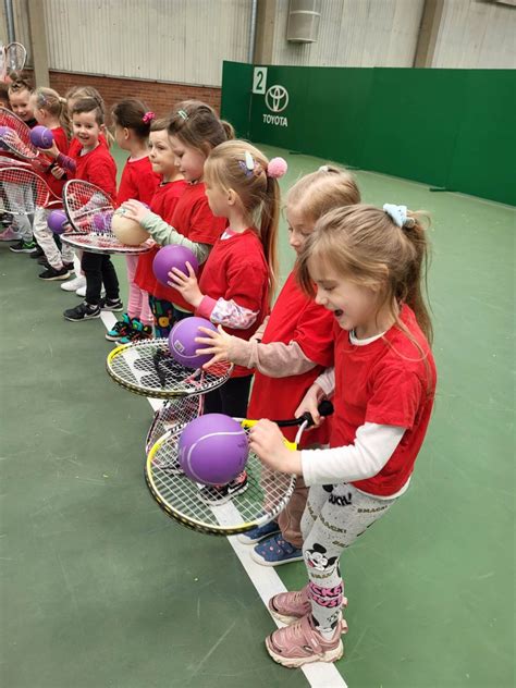 vaikai žaidžia lauko tenisą su treneriu