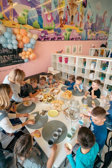 Darželio auklėtoja su vaikais žaidimų kambaryje