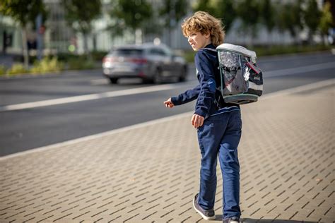 Vaikas su kuprine eina į mokyklą