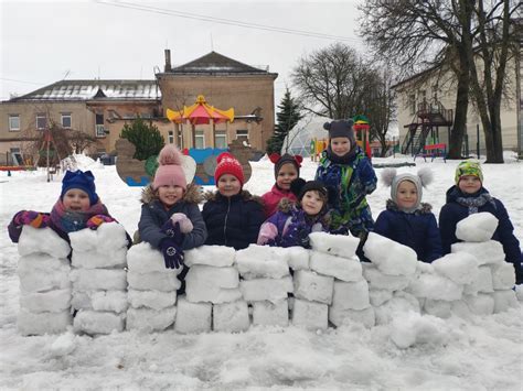 vaikai žiemą darželyje su sniego seniu