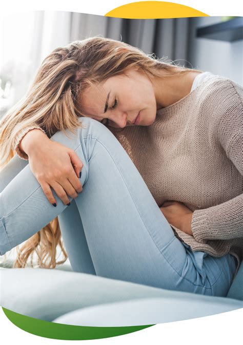 Moteris su šildymo pagalvėle ant pilvo