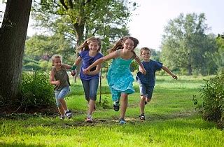 Vaikai žaidžia lauke darželyje su gamtos elementais