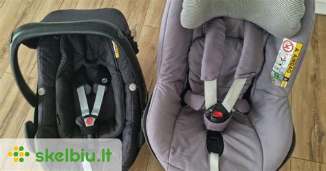 Vaikas, žiūrintis pro automobilio langą iš Maxi-Cosi kėdutės