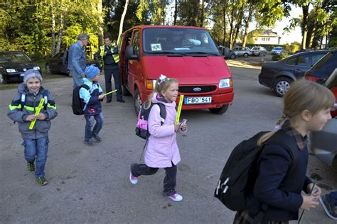 vaikai su saugos liemenėmis gatvėje