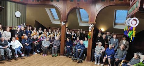 Nuotrauka, vaizduojanti globėją, padedantį senjorui namuose