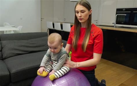 Kūdikis mankštinasi ant gimnastikos kamuolio