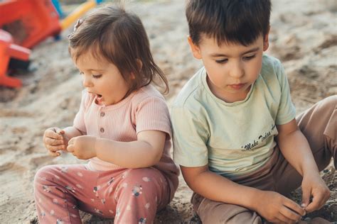 Vaikai žaidžia lauke su vandeniu ir smėliu