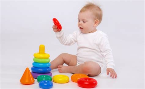 Kūdikis žaidžia su juodai baltomis kortelėmis pilvelio treniruočių metu