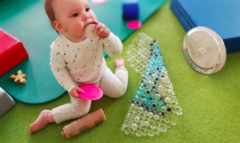 Kūdikis žaidžia su lavinamuoju kubu