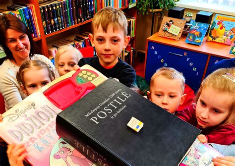 Vaikai bibliotekoje skaito knygas