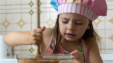 Vaikas gamina maistą vaikiškoje virtuvėlėje