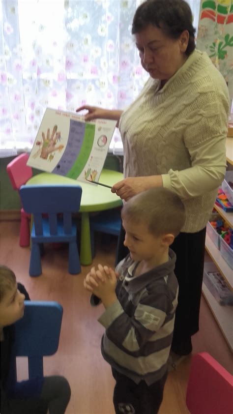 Nuotrauka, vaizduojanti gydytoją, apžiūrintį vaiką, ir šalia esančius tėvus